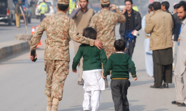 A Pakistani soldier escorts schoolchildren from the Army Public School after they were rescued. Source: Reuters