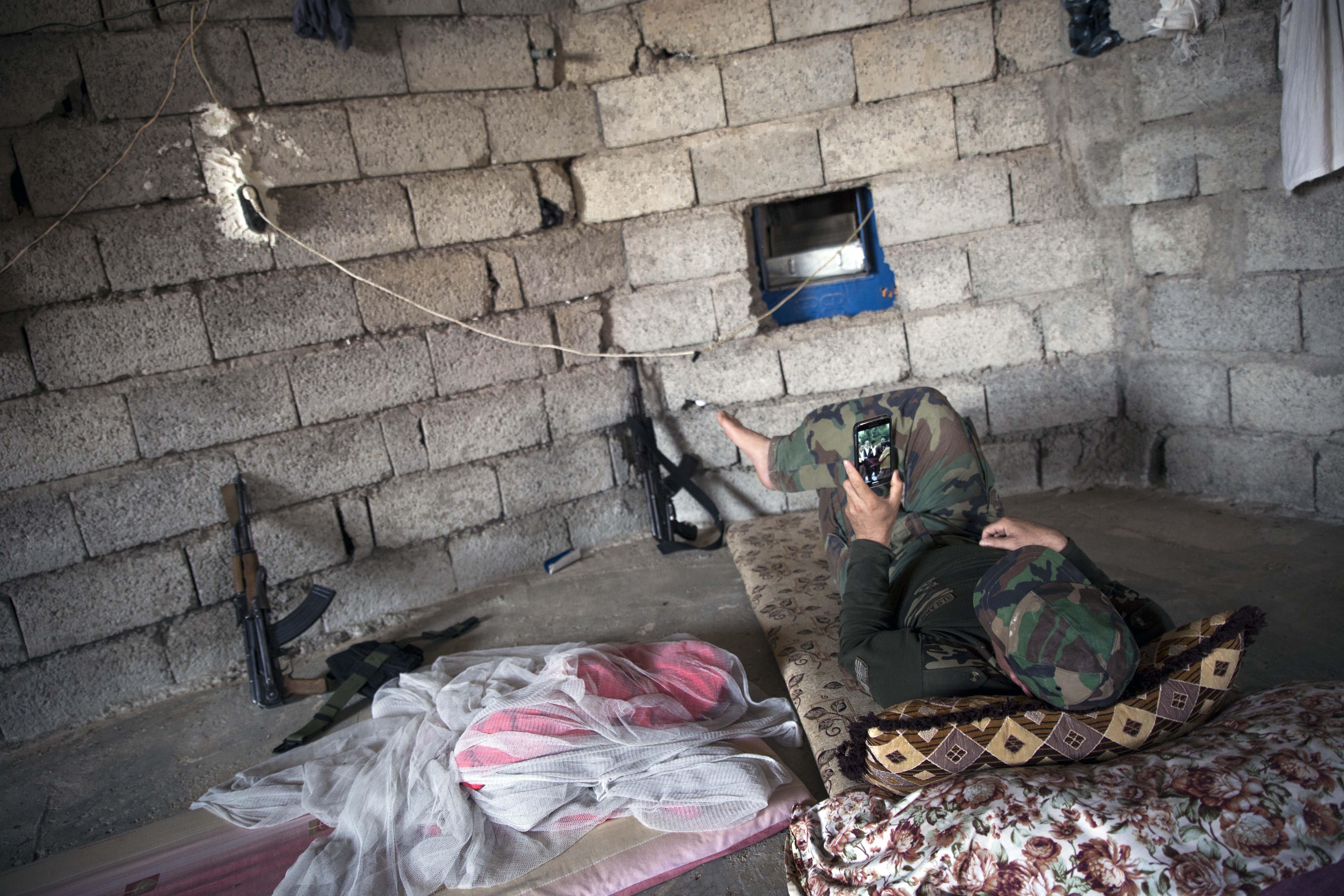 A Peshmerga fighter is using his phone for relaxation. Several fighters said there was not much to do: 