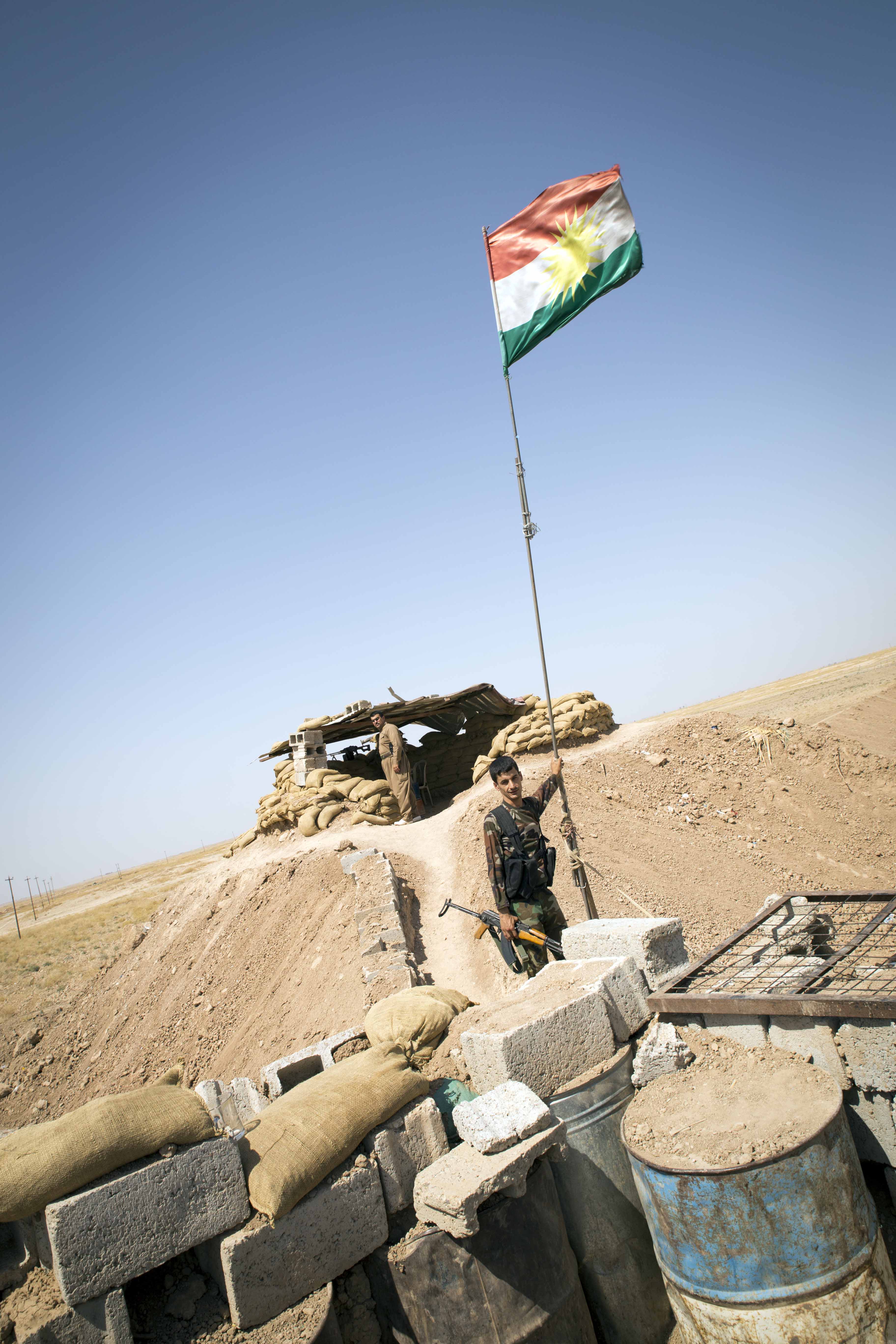 An outpost overlooking 'no man’s land'. The boy holding the flagpost is fighting together with his father at this part of the frontline.