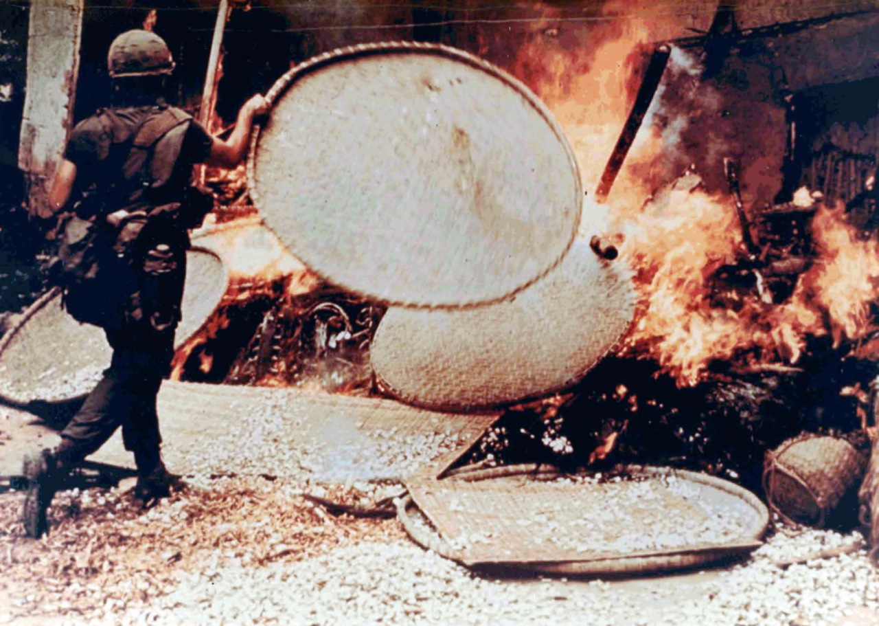 A US soldier burns a Vietnamese dwelling during the My Lai massacre, 1968, when between 350 and 500 unarmed civilians were killed by US soldiers.     